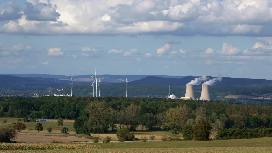 Atomkraftwerk neben Windrädern